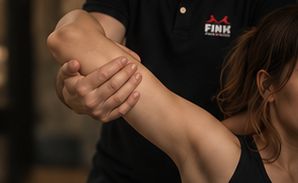 Therapeut mobilisiert behutsam die Schulter einer Patientin